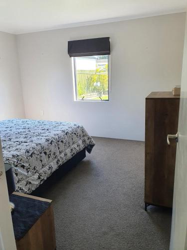 a bedroom with a bed and a window at Harbour Views House or Flat in Tahawai