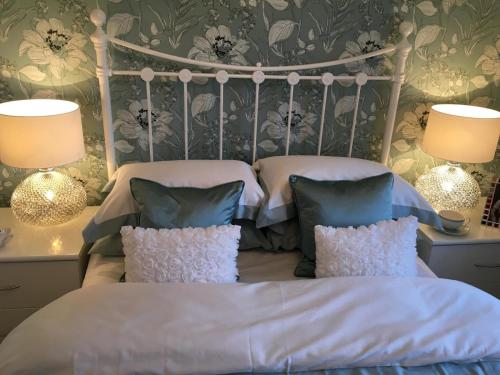 two beds in a bedroom with two lamps and two pillows at Premier stays in Warrington