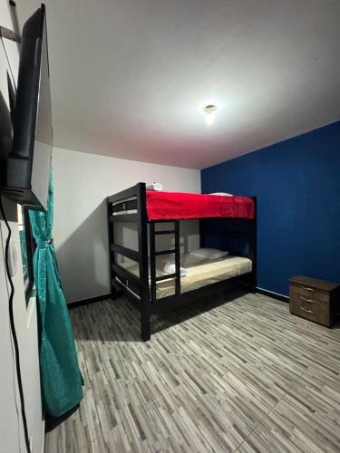 een kamer met 2 stapelbedden en een flatscreen-tv bij Apartahotel Vista Verde in El Peñón