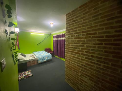a room with a brick wall and a bed in it at Home made guest house and netflix in Bhaktapur