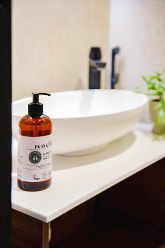 a bottle of soap sitting on a counter next to a sink at Vario Hotel in Kokkola