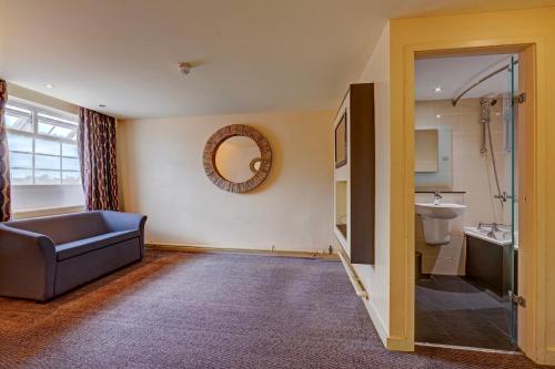 a bathroom with a sink and a toilet and a mirror at Manchester Airport Hotel by Dancenter in Manchester