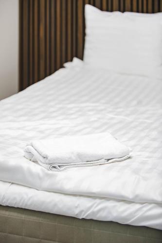 a white bed with white towels on it at Vario Hotel in Kokkola