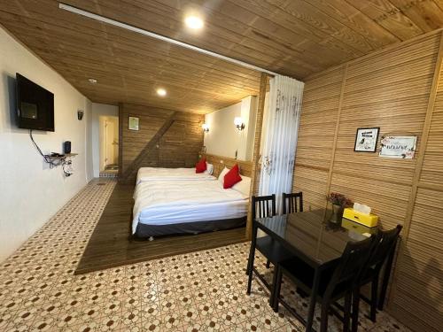 a bedroom with a bed and a table in a room at 九份迦南民宿 in Jiufen