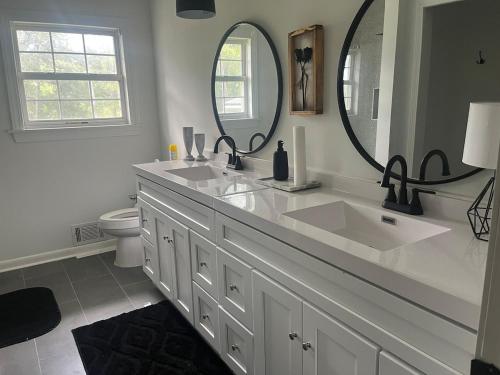 a bathroom with two sinks and a large mirror at Experience Serenity with Family and Friends in Macon
