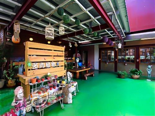 a store with green floors and a room with plants at Taichung Xinshe Garden Life Homestay B&B in Xinshe