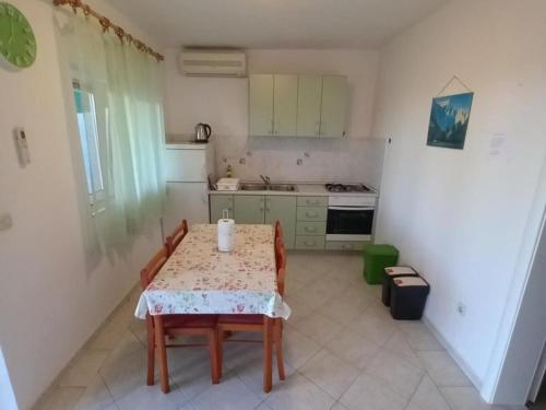 a kitchen with a table and two chairs and a kitchen with a stove at Comfort One Bedroom Apartment with Terrace and Sea view in Sveta Nedelja
