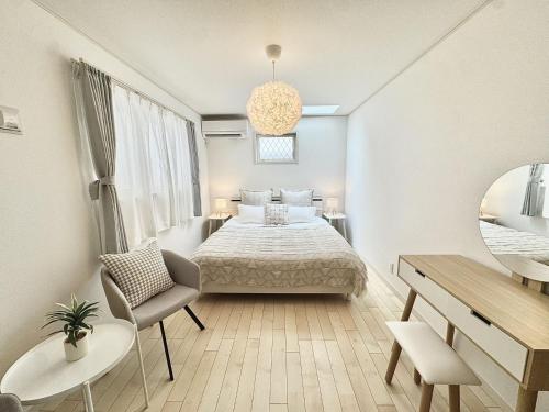 a white bedroom with a bed and a desk at Ryan inn 99平米 戸建貸切1組10名まで JR東十条駅徒歩3分 in Tokyo