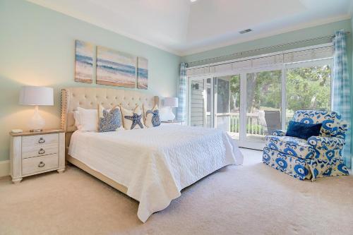 Un dormitorio con una cama y una silla y una ventana. en HO2875: 2875 Hidden Oak Drive, en Seabrook Island