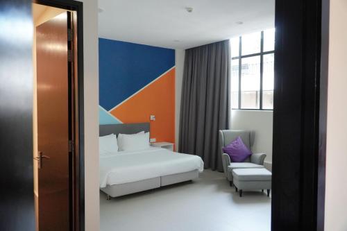 a hotel room with a bed and a chair at Hollandse Club Retreat in Singapore