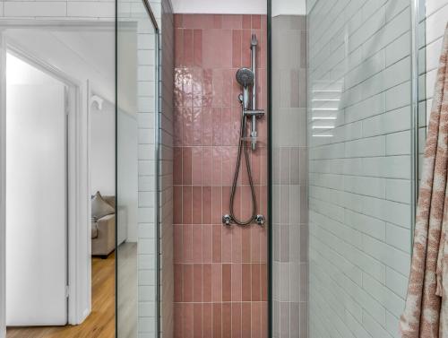 a bathroom with a shower with pink tile at Wave Whisperer in Kingscliff