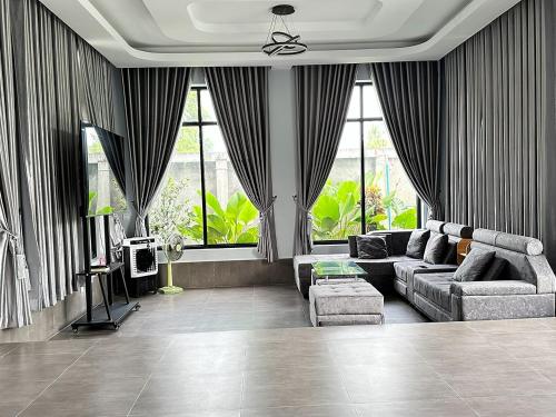salon z kanapą i oknami w obiekcie BTB Homestay w mieście Phumĭ Kâmpóng Âmpĭl