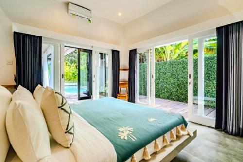 a bedroom with a large bed and large windows at Deimena Cozy 3 BR Private Pool Villa ZN353 in Pererenan