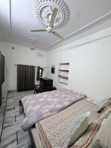 une chambre avec un lit et un ventilateur de plafond dans l'établissement Vidhya Haveli, à Pushkar