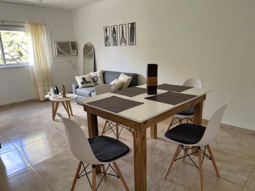 a living room with a wooden table and chairs at Apart Boulevard in Vuelta del Paraguayo