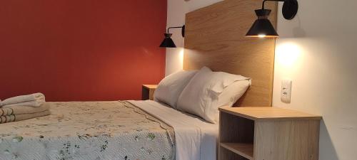 a bedroom with a bed with two night stands and two lamps at Studio planejado em itaipava in Araras Petropolis