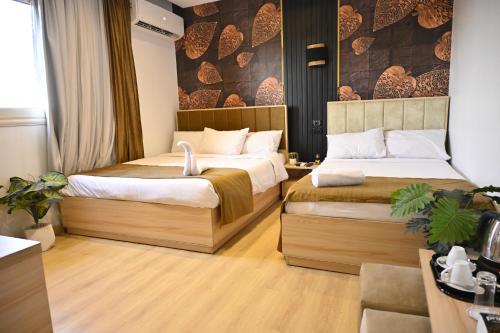 una habitación de hotel con dos camas en una habitación en Palm Pyramids View INN, en El Cairo