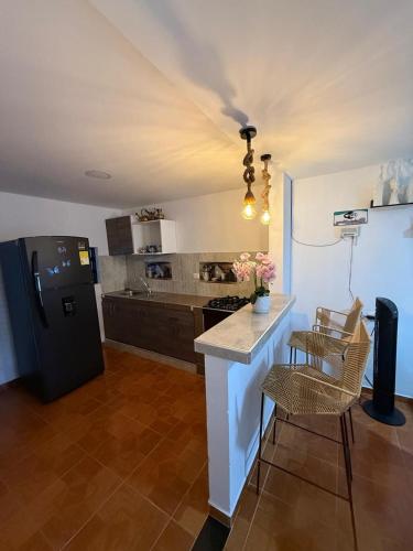 uma cozinha com geladeira, mesa e cadeiras em Hostal Maxim em Puerto Isaacs