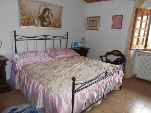 a bedroom with a large bed with pink sheets at La Casa di Walter in Palata