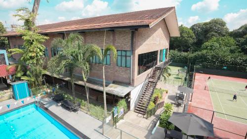 an aerial view of a house with a pool and a tennis court at Hollandse Club Retreat in Singapore