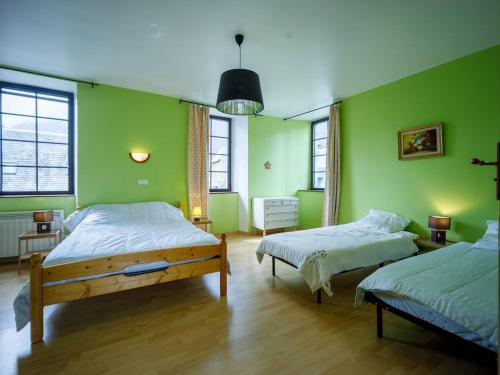 two beds in a room with green walls at Maison pour 6 à Loudenvielle avec WiFi gratuit - FR-1-695-92 in Loudenvielle
