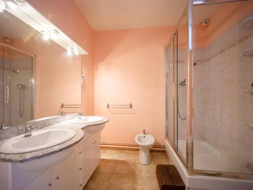 a bathroom with two sinks and a shower and a toilet at Maison pour 6 à Loudenvielle avec WiFi gratuit - FR-1-695-92 in Loudenvielle