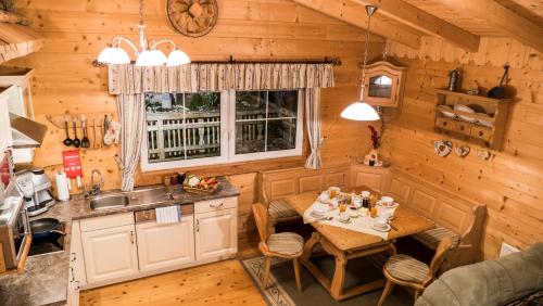 a kitchen and dining room with a table in a cabin at Almdorf im Winkl - Blockhüttendorf in Gröbming in Gröbming