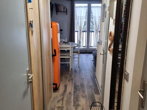 a hallway with an orange suitcase and a table in a room at Studio Cabine F4 en Station Ski - 200m des Pistes - FR-1-687-118 in Flaine