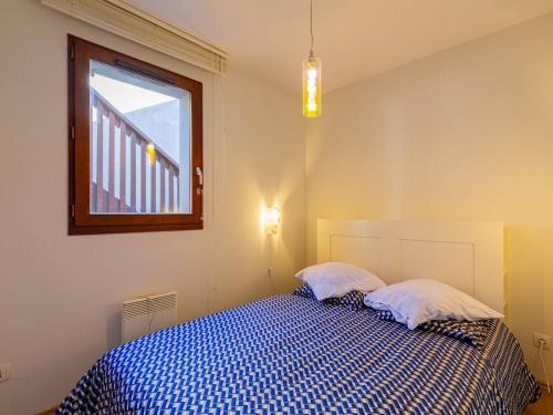 Schlafzimmer mit einem blauen und weißen Bett und einem Fenster in der Unterkunft Appartement charmant pour 5 à Loudenvielle, proche télécabine - FR-1-695-91 in Loudenvielle