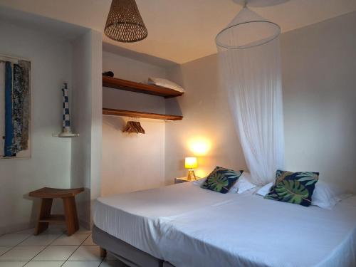 a bedroom with a white bed with a canopy at Anse Marine in Terre-de-Haut