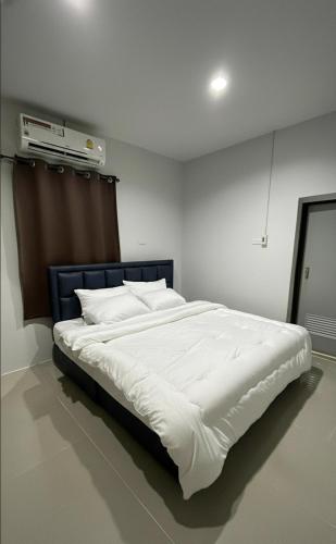 a bedroom with a large bed with white sheets at Phimpakan guesthouse in Nakhon Phanom