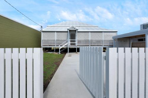a white fence in front of a house at CBD Holiday Home in Mackay