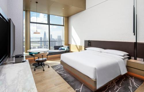 a bedroom with a large white bed and a desk at Renaissance Shenzhen Bay Hotel in Shenzhen
