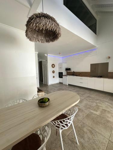 a dining room with a wooden table and chairs at Duplex Atypique et Authentique in Saint Martin