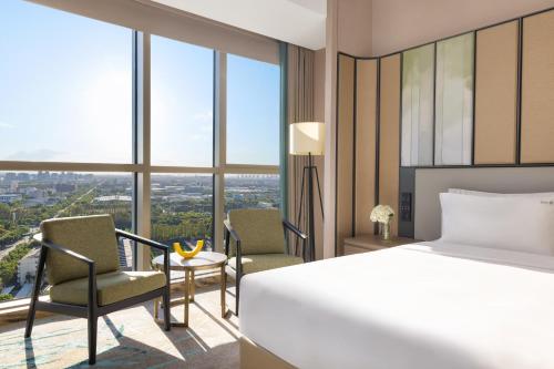 a hotel room with a bed and a desk and chairs at Holiday Inn Shanghai Minhang Center by IHG in Shanghai