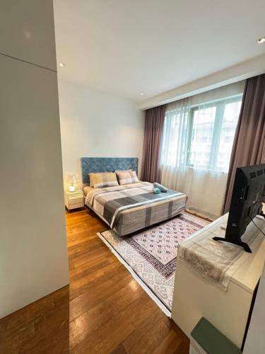 ein Schlafzimmer mit einem Bett und einem Fernseher darin in der Unterkunft KLCC Marc Residence by AZ Line in Kuala Lumpur