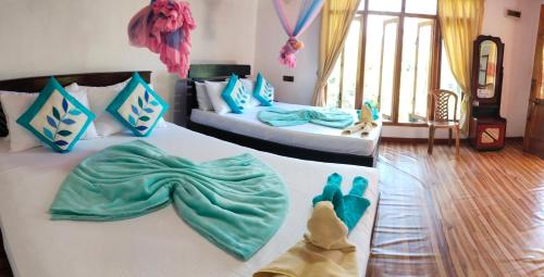 a bedroom with two beds with blue and green sheets at Ella Summer Leisure in Ella