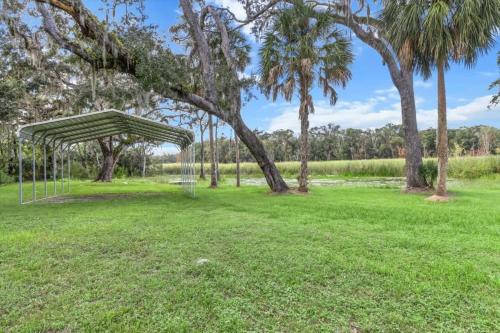 a metal canopy in a park with palm trees at Charming 3BR Waterfront Home - Private - Serene in Inverness