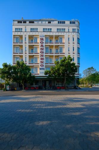 a large white building with a parking lot in front of it at Hồng Nhung Hotel Kiên Giang in Rạch Giá