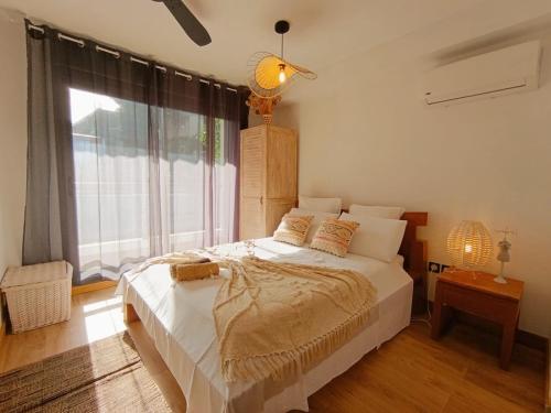 a bedroom with a large bed and a large window at Chambre Saint Gilles les bains1 in Saint-Paul