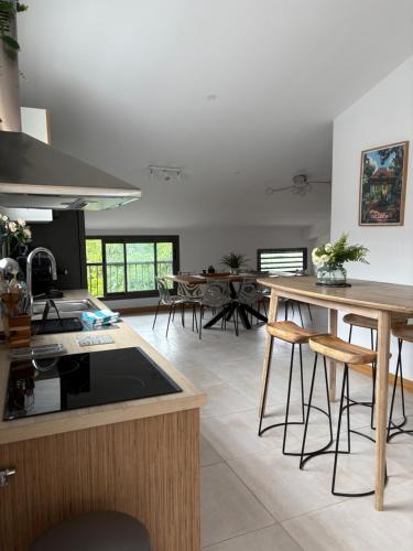 a kitchen with a table and some tables and chairs at Chambre Saint Gilles les bains1 in Saint-Paul