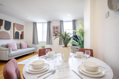 a dining room with a white table and chairs at Stylish 1BR Apt near Cardiff Castle in Cardiff