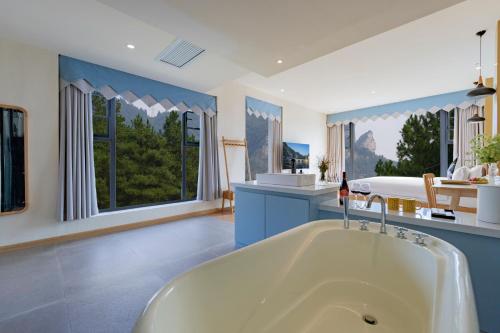 een grote badkamer met een bad in een kamer met ramen bij Azure Peaks-English Services-At National Forest Park with Free Shuttle in Zhangjiajie