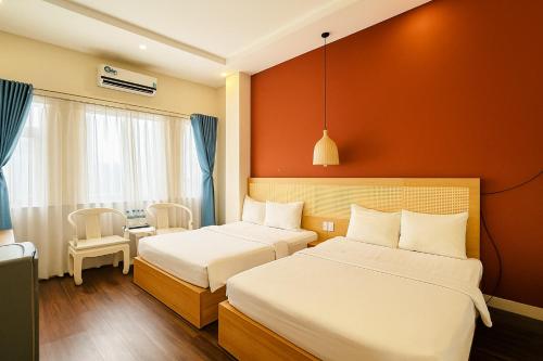 een hotelkamer met twee bedden en een tafel bij Saigon Central Hotel in Ho Chi Minh-stad