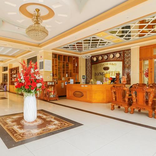 a lobby with a vase of flowers on a rug at Hồng Nhung Hotel Kiên Giang in Rạch Giá