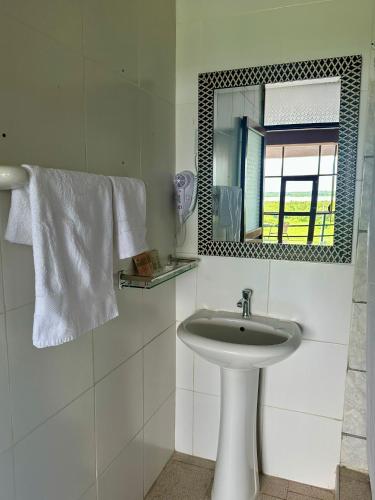 a white bathroom with a sink and a mirror at La Posada del Cauchero Hotel & Suites in Iquitos