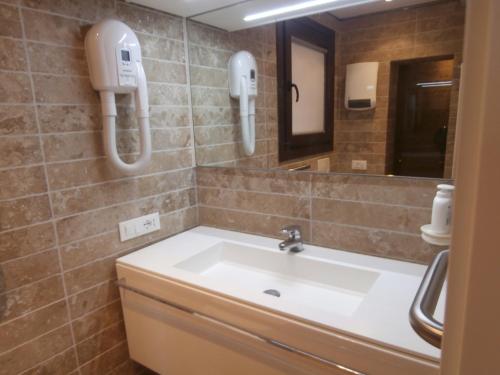 een badkamer met een wastafel en twee telefoons aan de muur bij Cocoloco in Venetië