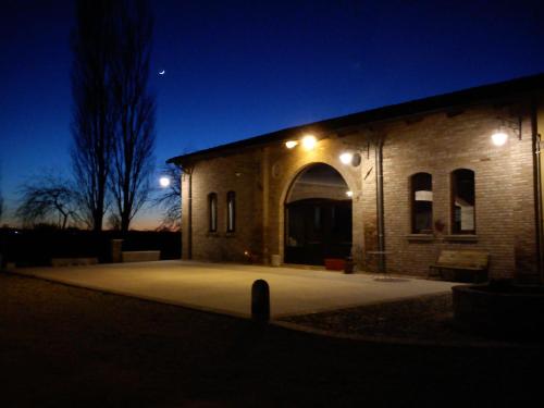 a brick building with an arched doorway at night at Corte Pioppazza in Ceresara