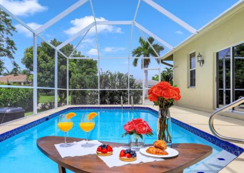een zwembad met een tafel met eten en drinken bij Marco Beach House l Private Pool in Marco Island