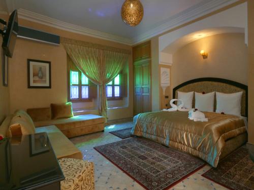 1 dormitorio con 1 cama grande y 1 sofá en Riad Zaki, en Marrakech